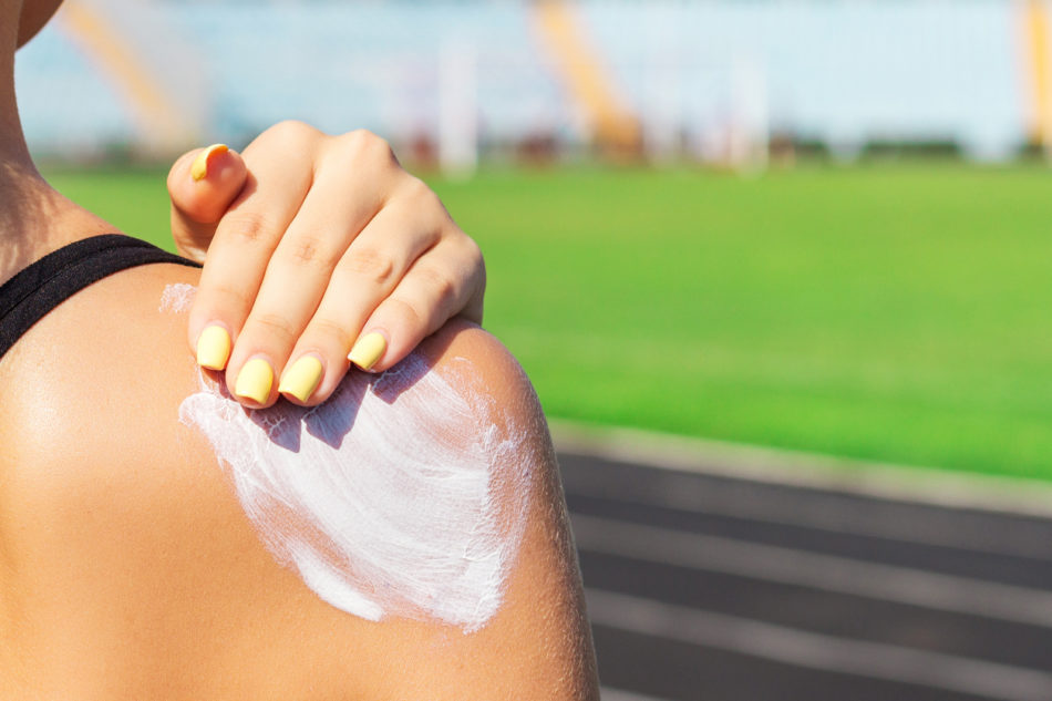 Woman applying sunscreen at sports event