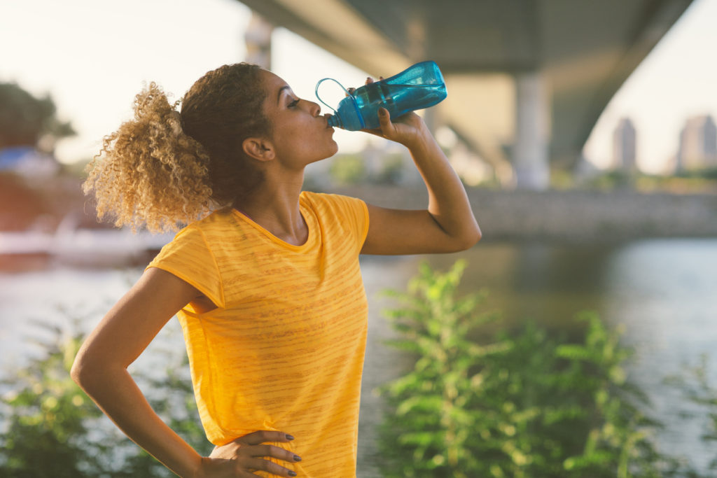 Woman drinking water after a run
