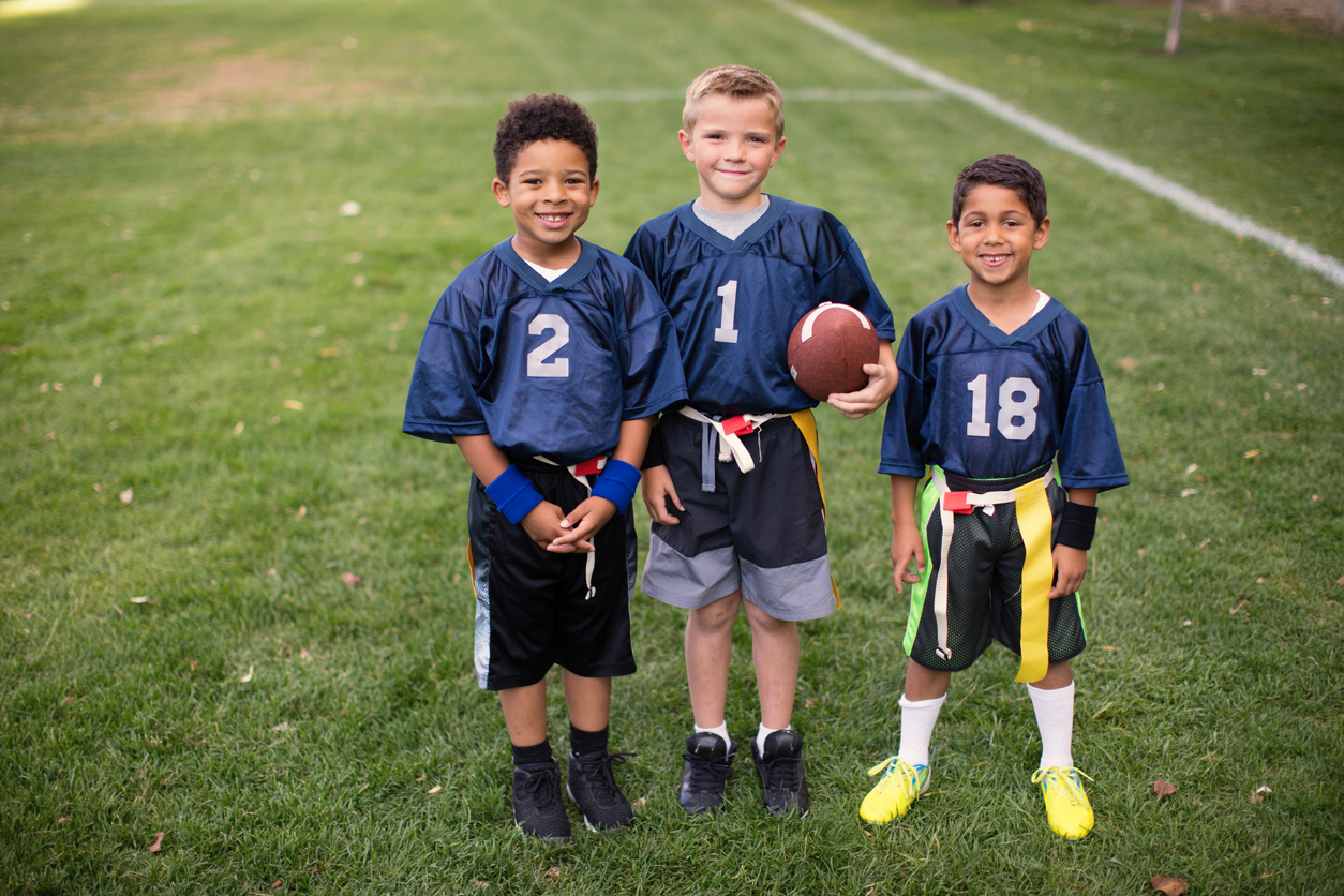 Three Young Boys and Teammates Play Flag Football